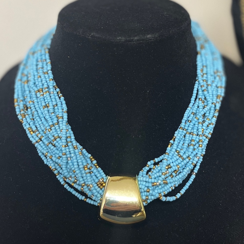 Baby blue, 23 strand, seed bead necklace. Gold focal slide. 18-20” NIP, weighted